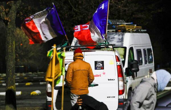 People walk by vehicles with banners and flags parked outside the city center of Brussels, on Feb. 14, 2022. (Olivier Matthys/AP Photo)