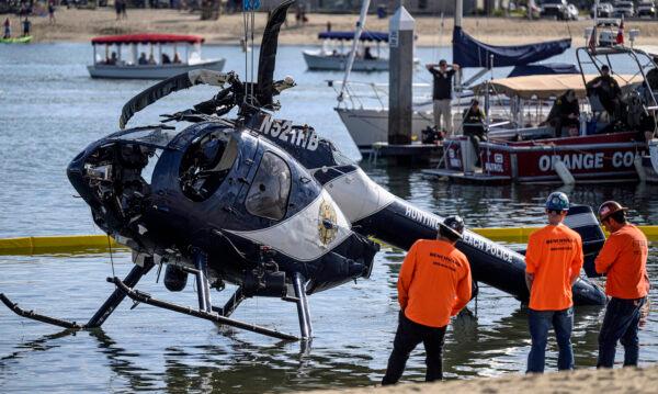 A crane is used to lift a Huntington Beach Police helicopter out of the water in Newport Beach, Calif., on Feb. 20, 2022. Officer Nicholas Vella, a 14-year veteran of the force, died in the accident. (Mindy Schauer, Orange County Register/SCNG)