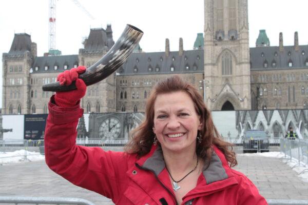 Benita Pedersen holds her symbol of hope, freedom, and strength—a steer horn—on Parliament Hill in Ottawa. Pedersen is a “Freedom Leader” and is supporting truckers in their Freedom Convoy protest in central Ottawa. (Richard Moore/The Epoch Times)