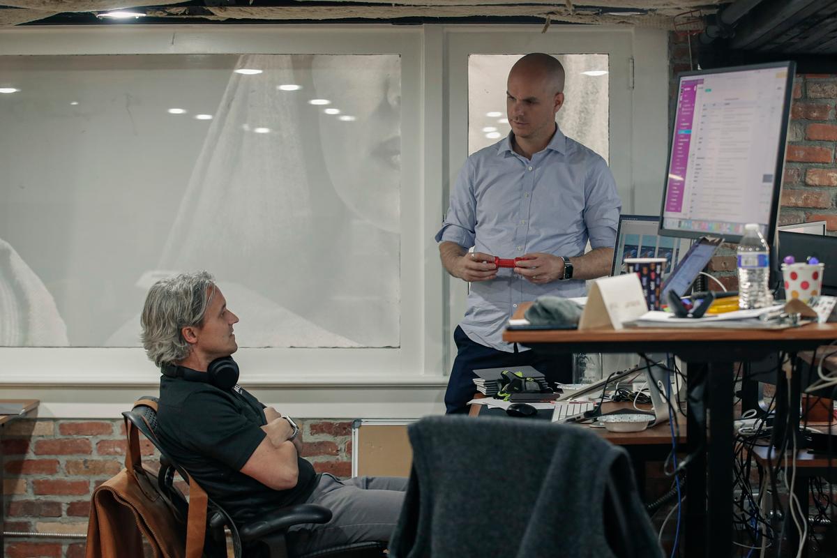 Neal (R) discusses projects with a member of the Angel Studios team. (George Frey for American Essence)