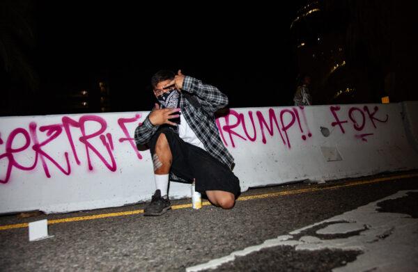 A man displays gang signs after tagging the 110 Freeway in Los Angeles on Nov. 9, 2016. (John Fredricks/The Epoch Times)
