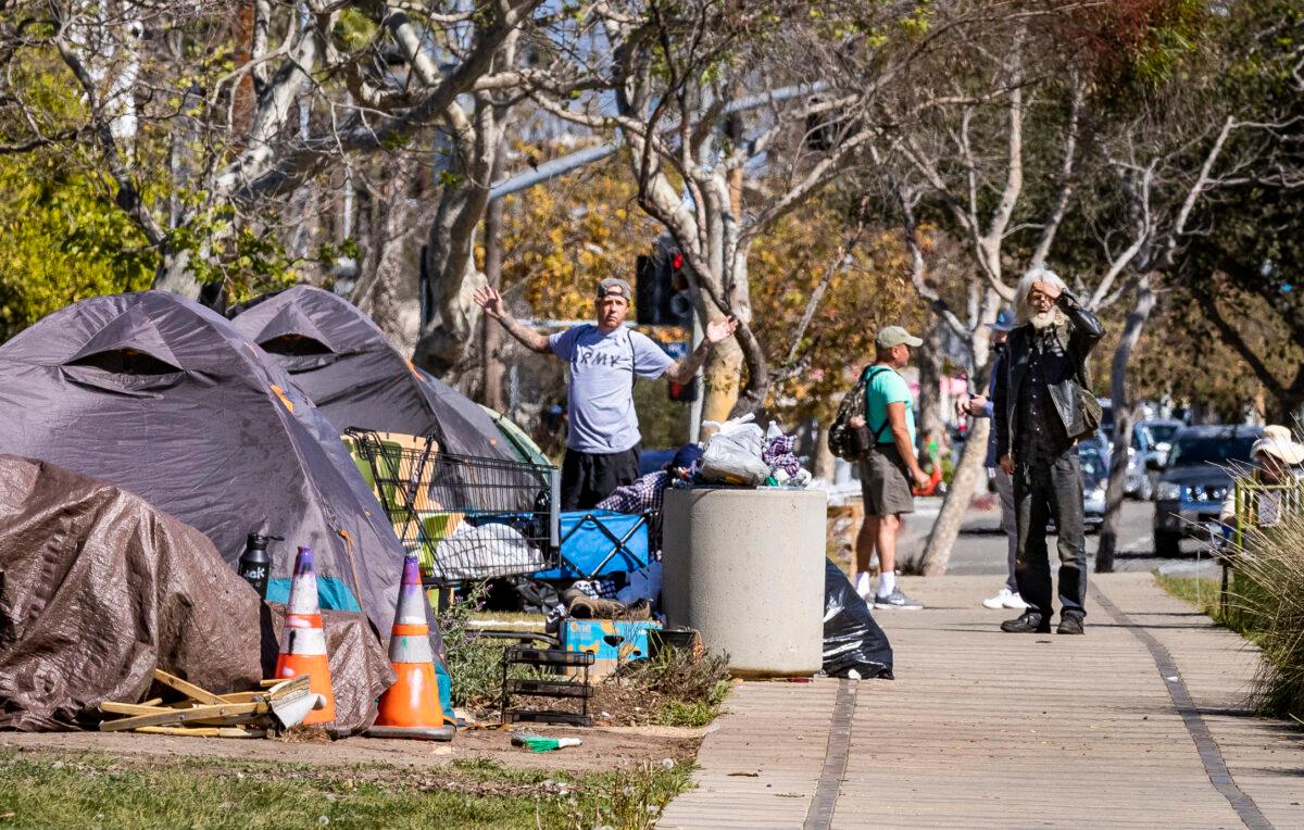 Men emerge from their tents located in a homeless encampment in front of the Abbot Kinney Memorial Branch Library in Venice, Calif., on Feb. 18, 2022. (John Fredricks/The Epoch Times)