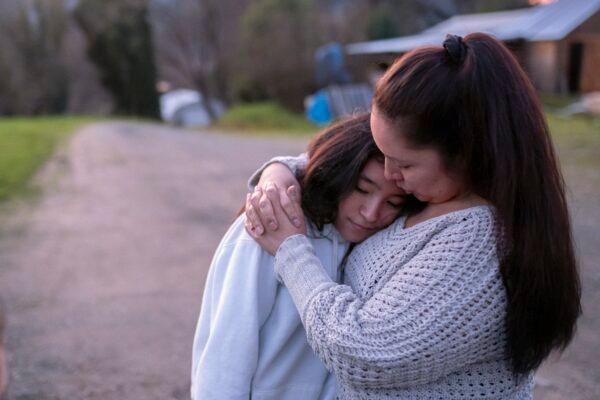 Brandice Davis (R) hugs her daughter Maile Kane, 13, while talking about the disappearance of Davis' friend Emmilee Risling at their home in Hoopa, Calif., on Jan. 20, 2022. (Nathan Howard/AP Photo)