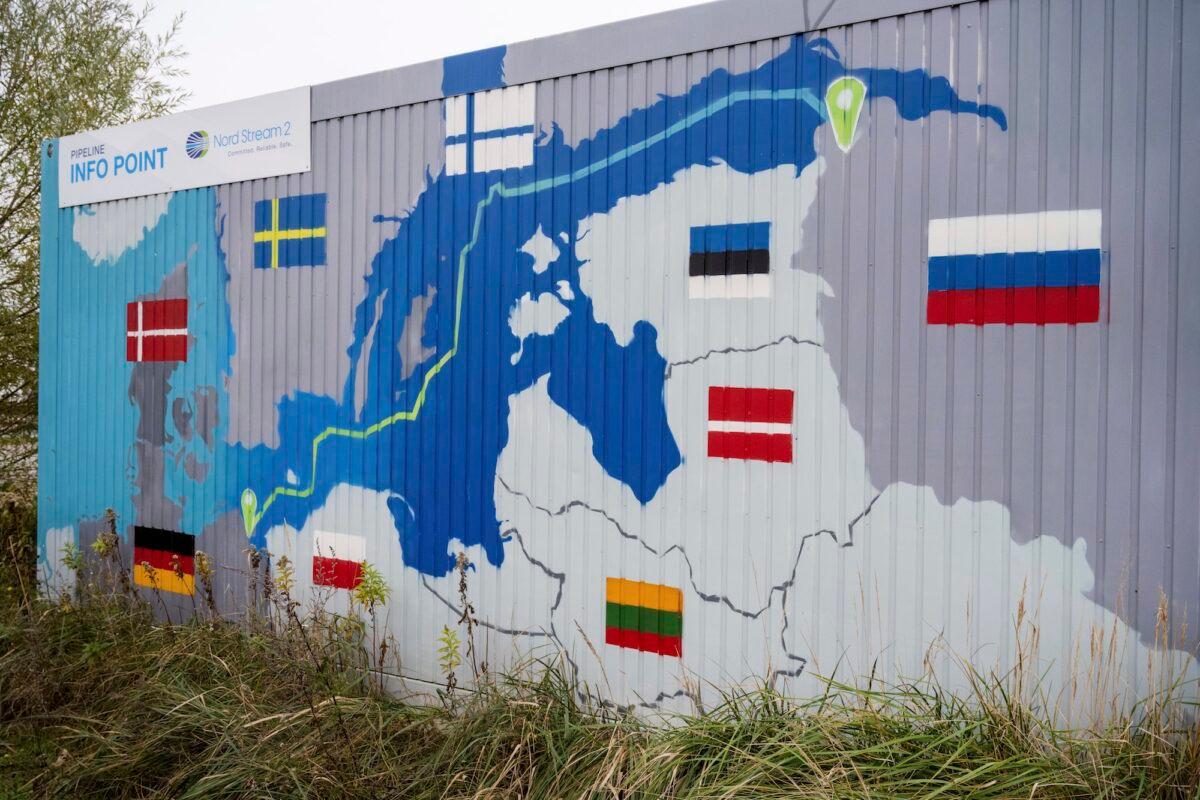 A sign reading "Nord Stream 2 Committed. Reliable. Safe," hangs above a painted map of the Nord Stream 2 pipeline from Russia to Germany at a station in the Lubmin, Germany, in 2021. (Stefan Sauer/DPA via AP)