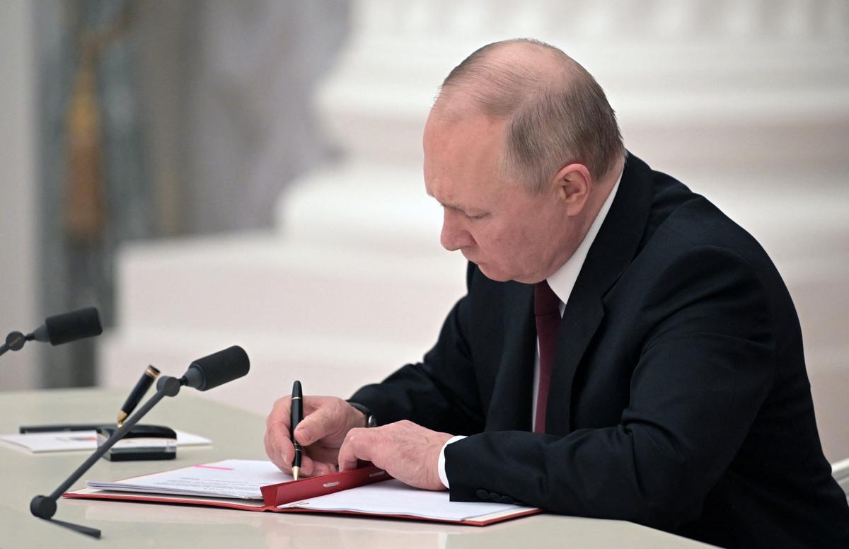 Russian President Vladimir Putin signs documents, including a decree recognizing two Russian-backed breakaway regions in eastern Ukraine as independent, during a ceremony at the Kremlin in Moscow on Feb. 21, 2022. (Alexey Nikolsy/Sputnik/AFP via Getty Images)