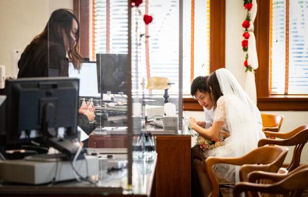 A couple signs marriage documents at Old Orange County Courthouse in Santa Ana, Calif., on Feb. 22, 2022.