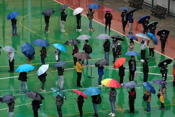Residents line up to get tested for the coronavirus at a temporary testing center despite the rain in Hong Kong, on Feb. 22, 2022. (Kin Cheung/AP Photo)