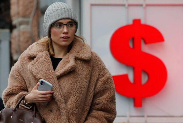 A woman walks past a board showing the U.S. dollar sign in Saint Petersburg, Russia, on Feb. 22, 2022. (Anton Vaganov/Reuters)