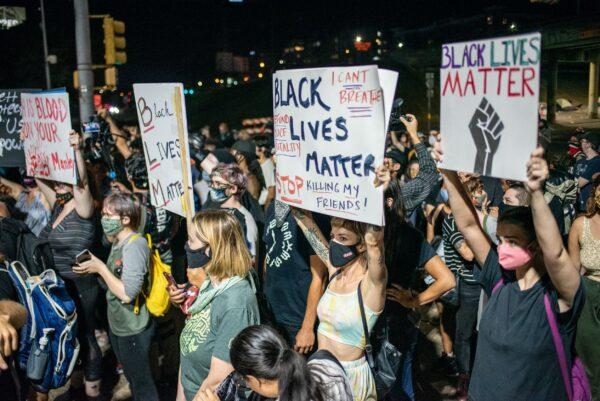 People hold up signs outside the Austin Police Department in Texas on July 26, 2020. (Sergio Flores/Getty Images)