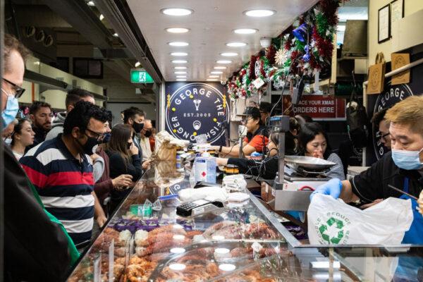 People wear a face mask as they shop at George the Fishgonger shop at the Queen Victoria Market in Melbourne, Australia, on Dec. 24, 2021. (Diego Fedele/Getty Images)