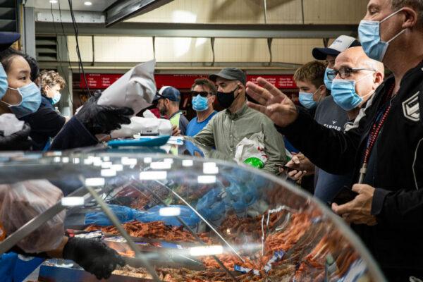 People shop for fish at the Queen Victoria Market on Christmas Eve in Melbourne, Australia, on December 24, 2021. (Diego Fedele/Getty Images)
