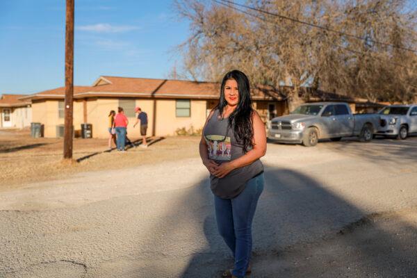 Katherine Vasquez stands near the home that was hit by a truck during a high-speed chase in Brackettville, Texas, on Feb. 18, 2022. (Charlotte Cuthbertson/The Epoch Times)