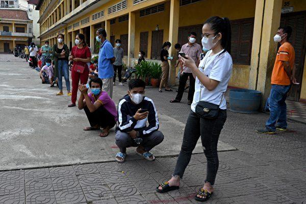 People wait in line to receive the Sinopharm vaccine from China at a school in Phnom Penh, Cambodia, on April 30, 2021 as part of a government campaign to halt the increasing number of COVID-19 coronavirus cases. (Tang Chhin Sothy/AFP)