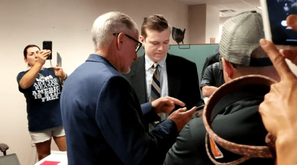 Screenshot from video showing legislative aide to Florida Rep. Chuck Brannan being handed a framed Oath Breakers Hall of Shame certificate by Republican Liberty Caucus leader Bob White. (Courtesy of Matt Collins)