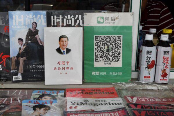 The QR payment code for Wechat Pay (R) beside a book about Chinese President Xi Jinping, titled "Xi Jinping; The Governance of China," at a news stand in Beijing on Sept. 18, 2020. (Greg Baker/AFP via Getty Images)