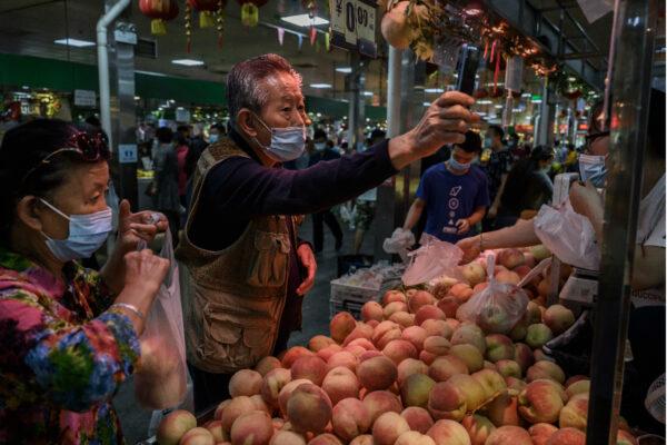 A Chinese customer uses his mobile to pay via a QR code with the WeChat app at a local market in Beijing on Sept. 19, 2020. (Kevin Frayer/Getty Images)