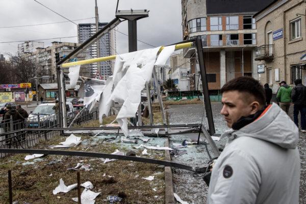 People stand around a damaged structure caused by a rocket in Kyiv, Ukraine, on Feb. 24, 2022. Overnight, Russia began a large-scale attack on Ukraine, with explosions reported in multiple cities and far outside the restive eastern regions held by Russian-backed rebels. (Chris McGrath/Getty Images)