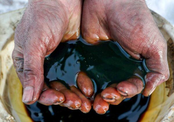 An employee holds a sample of crude oil at the Yarakta oilfield, owned by Irkutsk Oil, in Russia on March 11, 2019. (Vasily Fedosenko/Reuters)