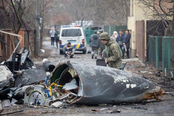 A Ukrainian Army soldier inspects fragments of a downed aircraft in Kyiv, Ukraine, on Feb. 25, 2022. (Vadim Zamirovsky/AP Photo)