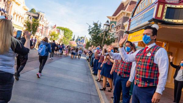 In this handout photo provided by Disneyland Resort, guests are waved to by workers as they take in the sights and sounds of Main Street U.S.A. at the Disneyland Resort in Anaheim, Calif., on April 30, 2021. (Christian Thompson/Disneyland Resort via Getty Images)