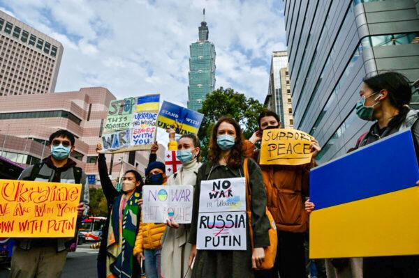 A group of Slavic people living in Taiwan display placards protesting Russia's military invasion of Ukraine, in Taipei on Feb. 25, 2022. (Sam Yeh/AFP via Getty Images)