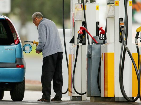 A man uses a fuel dispenser to fill his car up with petrol at a petrol station in Melbourne, Australia, on July 23, 2013. (Scott Barbour/Getty Images)