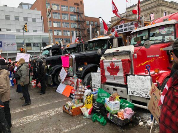 Food and other necessities donated to truckers are left beside trucks parked in front of Parliament Hill in Ottawa on Feb. 6, 2022. (Noé Chartier/The Epoch Times)