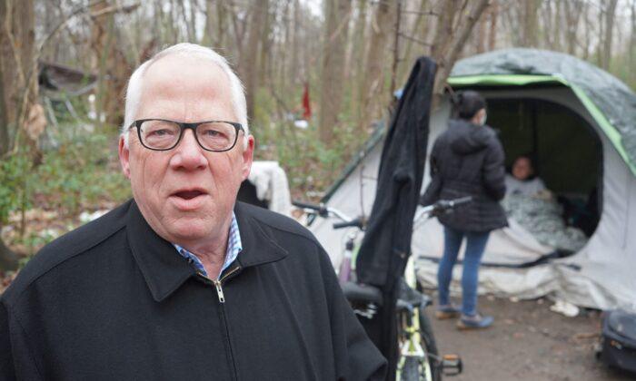 Tyler's Mayor Don Warren stands at a homeless encampment in the city limits on Feb. 24, 2022, while the "Point in Time" survey is conducted behind him. Warren oversaw the creation of Tyler's Homeless Response Unit in October.  (Patrick Butler/The Epoch Times)