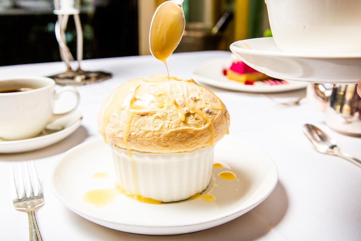 The Creole bread pudding soufflé, the signature dessert, is finished tableside. (Courtesy of Commander's Palace)