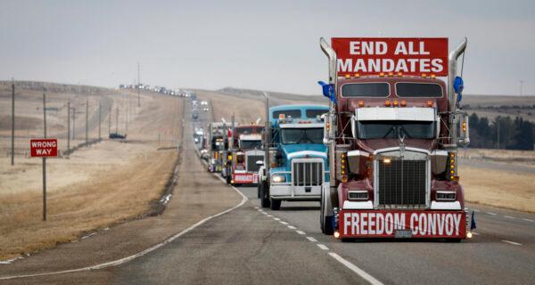 Protesters in a truck convoy leave the Canada–U.S. border crossing after demonstrating against COVID-19 mandates for over two weeks, in Coutts, Alberta, on Feb. 15, 2022. (Jeff McIntosh/The Canadian Press)