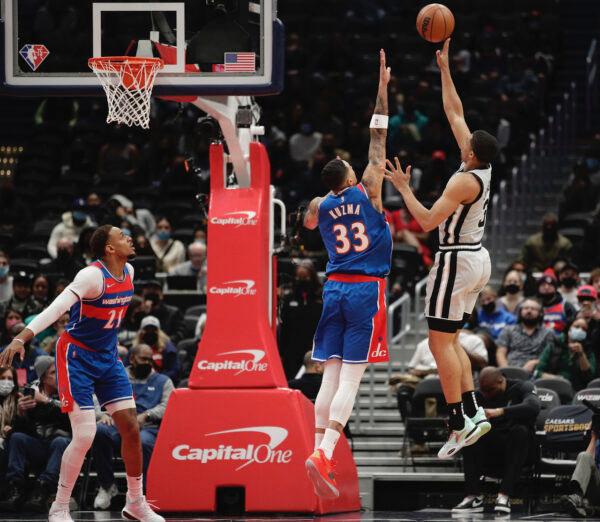 San Antonio Spurs' Keldon Johnson (R) shoots the ball as Washington Wizards’ Kyle Kuzma (33) defends during the first half of an NBA basketball game in Washington, on Feb. 25, 2022. (Luis M. Alvarez/AP Photo)