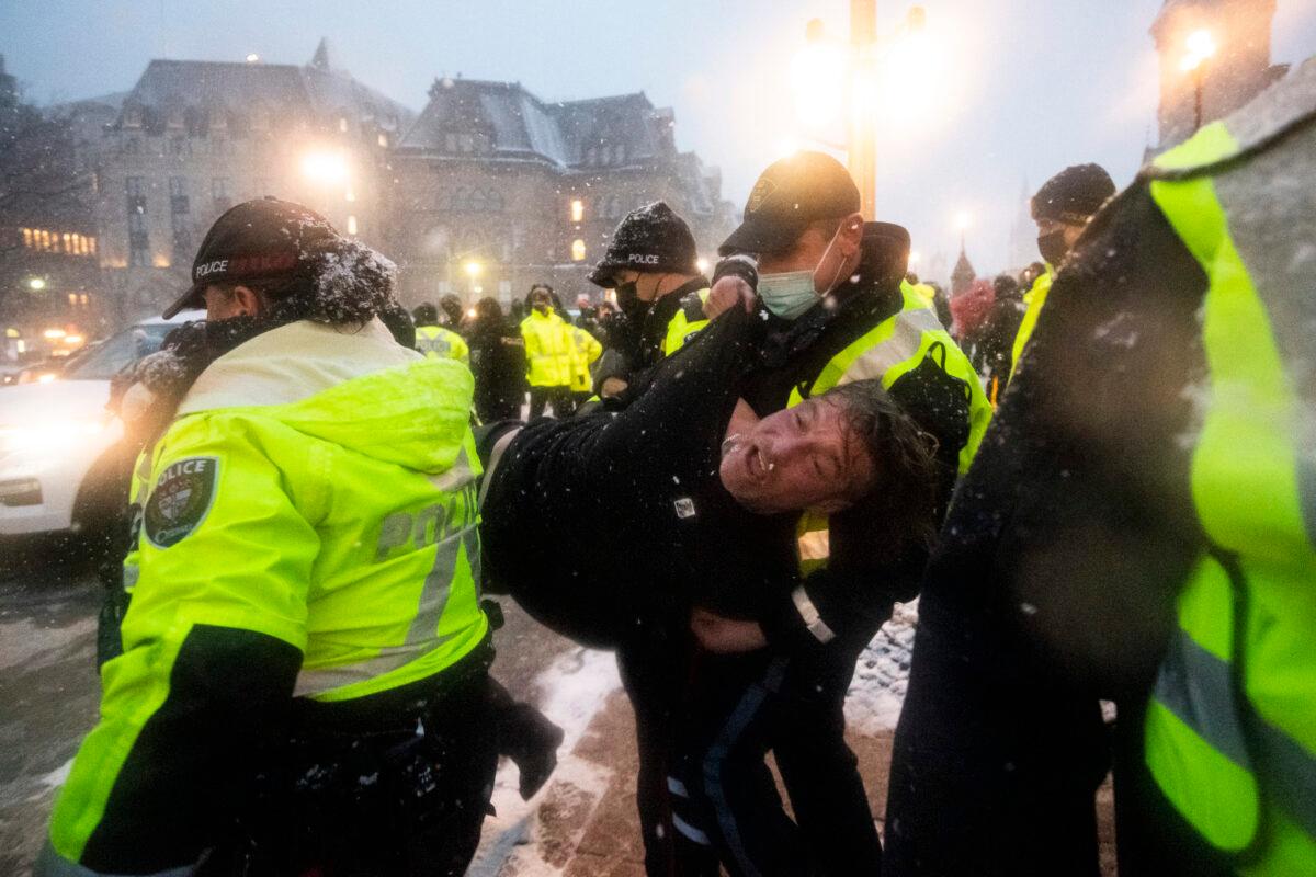 Police make an arrest on the 21st day of the trucker protest against COVID-19 mandates and restrictions, after the federal government invoked the Emergencies Act, in downtown Ottawa on Feb. 17, 2022. (Justin Tang/The Canadian Press)