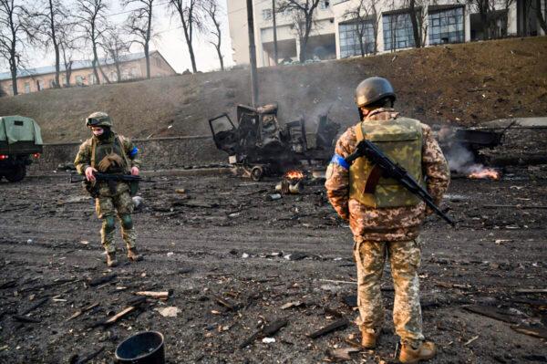 Ukrainian service members look for unexploded shells after fighting with Russian forces in Kyiv, Ukraine, on Feb. 26, 2022. (Sergei Supinsky/AFP via Getty Images)