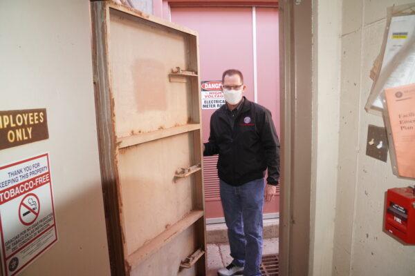 Ron Coleman, senior communications officer for Maricopa County Emergency Management in Phoenix, Ariz., displays the reinforced steel blast door to the agency's former underground fallout shelter on Feb. 24, 2022. (Allan Stein/The Epoch Times)