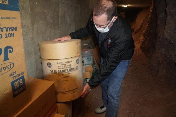 Ron Coleman, senior communications officer for Maricopa County Emergency Management in Phoenix, Ariz., inspects a sanitation kit that was used in the agency's former fallout shelter built in 1956. (Below) Coleman shows how the shelter was built into the mountainside to shield against radiation from fallout. (Allan Stein/The Epoch Times)