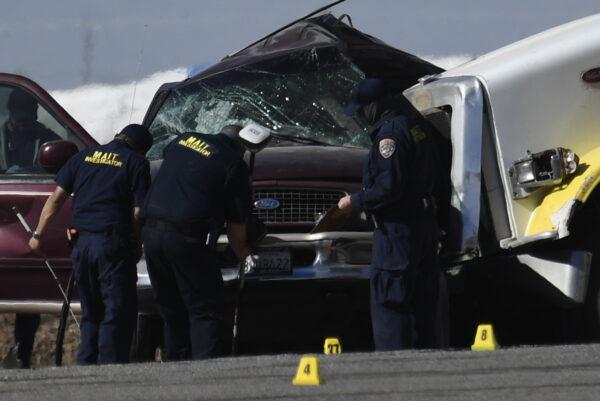 Investigators look over the scene of a crash between an SUV and a semi-truck full of gravel near Holtville, Calif., on March 2, 2021. (Patrick T. Fallon/AFP)