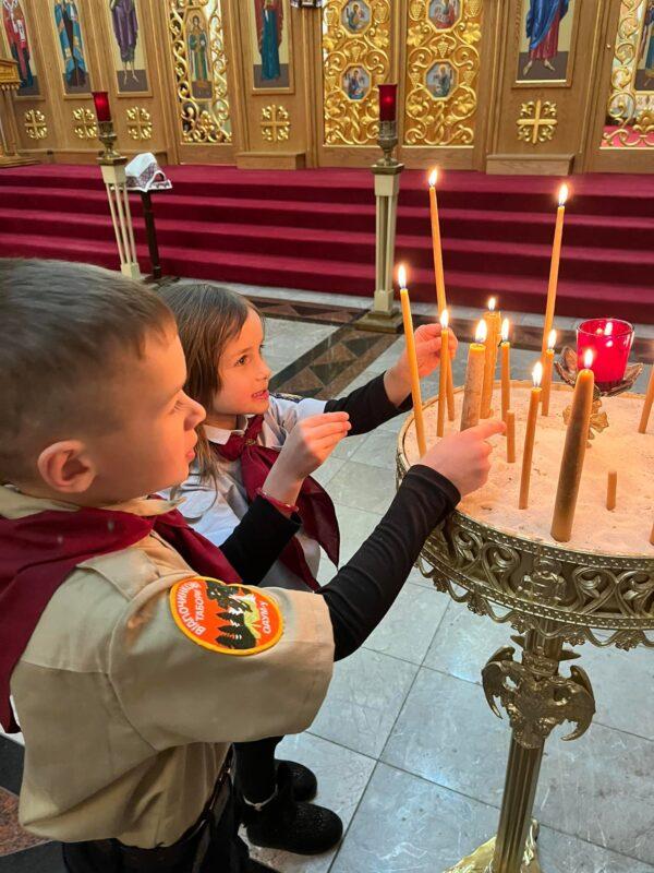 Dmytro Skyba (L), 7, and his sister, Zoriana (R), 4, each light a candle in support of Ukraine during a prayer service at St. Andrew Ukrainian Orthodox Church in Bloomingdale, Ill. on Feb. 24. The Skybas are of Ukrainian descent, and are concerned about people they know living in the country. (Courtesy Tania Pohuliaj-Skyba)