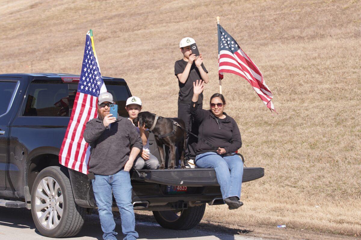 Convoy supporters wave American flags by the side of the road in Oklahoma on Feb. 27, 2022. (Enrico Trigoso/The Epoch Times)