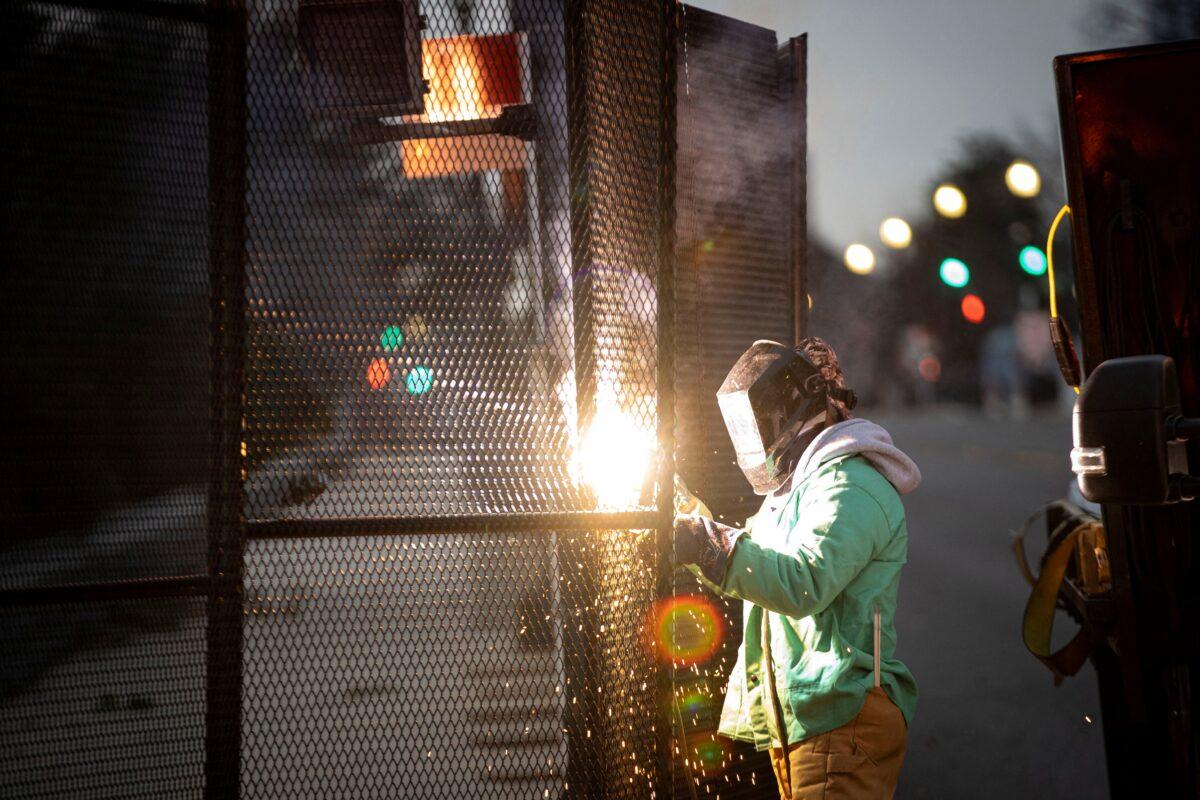 A worker welds security fencing around the perimeter of the U.S. Capitol on Feb. 27, 2022, ahead of the upcoming State of the Union with U.S. President Joe Biden. (Al Drago/Reuters)