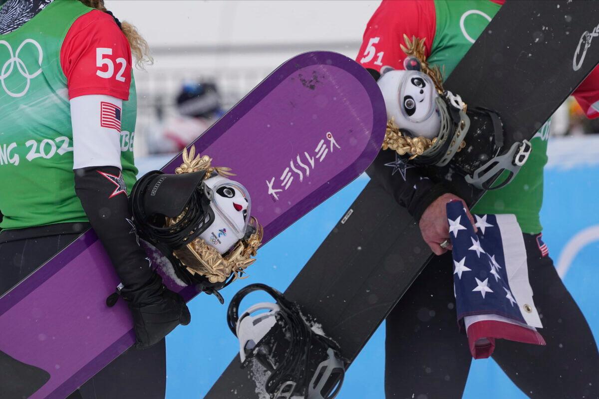 Gold medal winners Lindsey Jacobellis and Nick Baumgartner of the United States walk off after the venue award ceremony for the mixed team snowboard cross finals at the 2022 Winter Olympics in Zhangjiakou, China, on Feb. 12, 2022. (Gregory Bull/AP Photo)