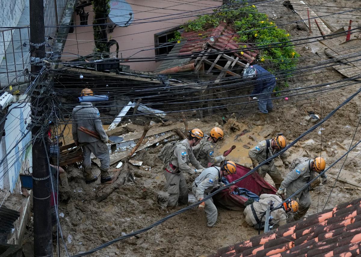 Rescue workers carry the body of a landslide victim in Petropolis, Brazil, on Feb. 16, 2022. (Silvia Izquierdo/AP Photo)