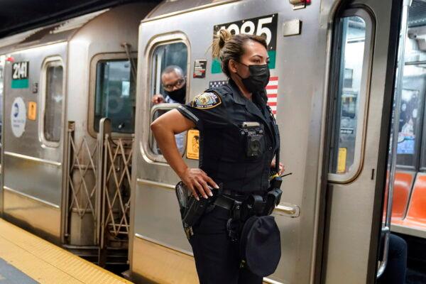 A New York Police Department officer and a subway conductor look down the subway platform at the Grand Central subway station in New York, on May 18, 2021. (Frank Franklin II/AP Photo)