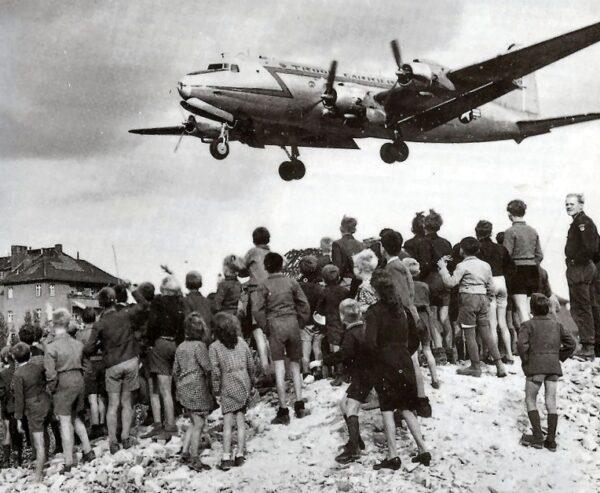 People watch a C-54 come in to land at Berlin Tempelhof Airport in 1948. (Public Domain)