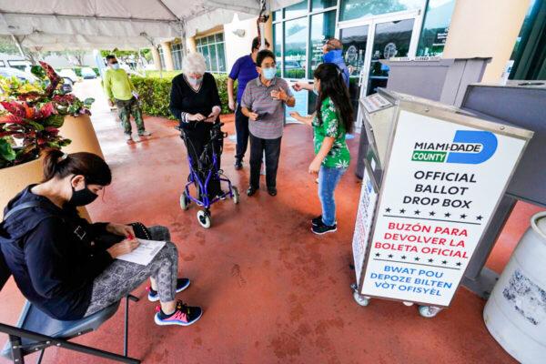 Voters prepare to turn in their mail-in ballots, at the Miami-Dade County Elections Department in Doral, Fla., on Oct. 6, 2020. (Wilfredo Lee/AP Photo)