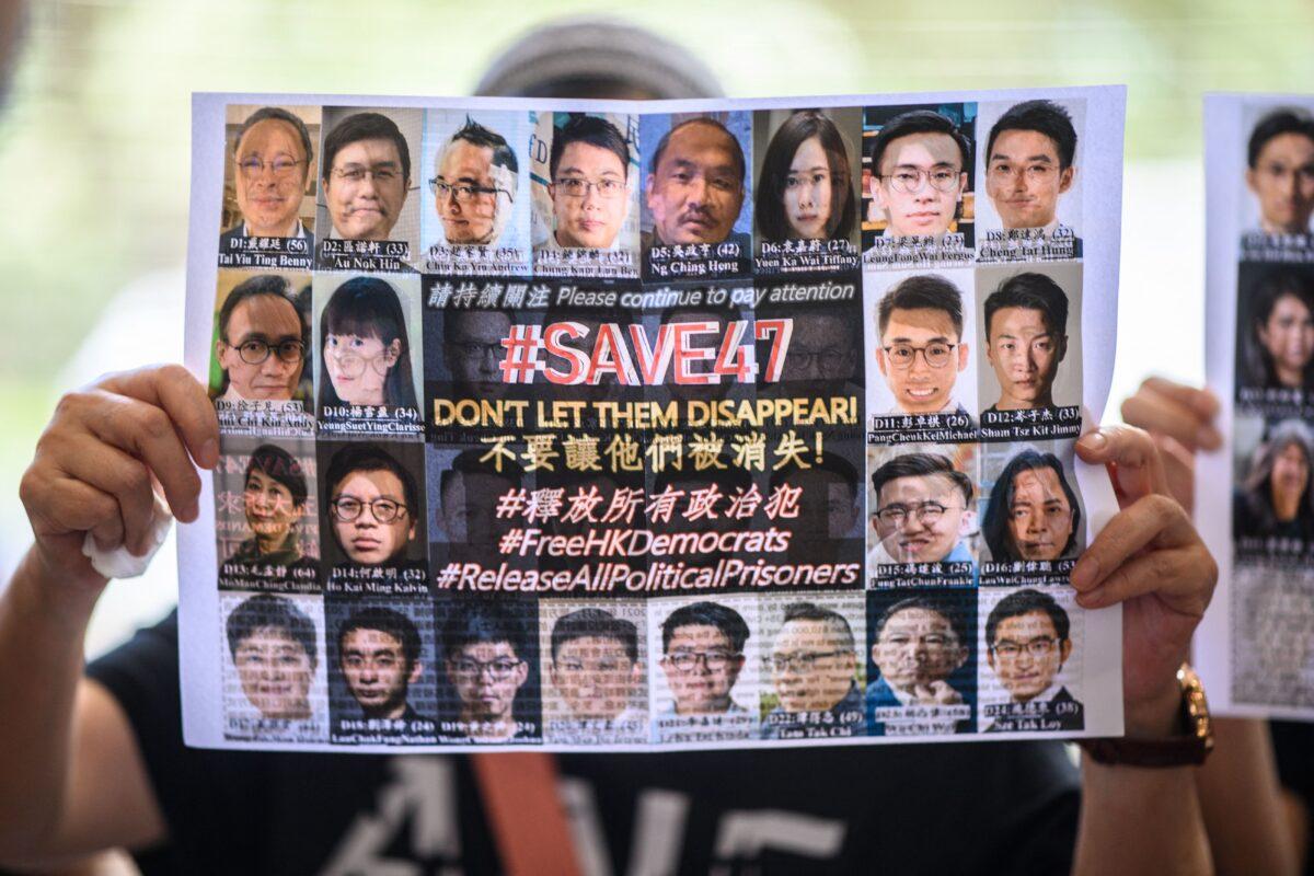 A supporter holds a poster showing some of the 47 pro-democracy activists on trial on charges of conspiracy to commit subversion under the national security law for taking part in unauthorized pro-democracy primaries in July 2020 at the West Kowloon Court in Hong Kong on July 8, 2021. (Anthony Kwan/AFP via Getty Images)
