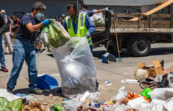 Los Angeles sanitation workers clean up trash left in Venice Beach, Calif., on June 8, 2021. (John Fredricks/The Epoch Times)