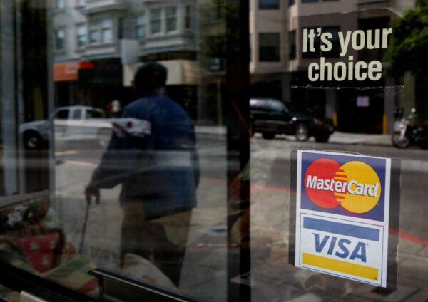 A window sticker advertising Visa and Mastercard credit cards hangs in a window in San Francisco on Feb. 25, 2008. (Justin Sullivan/Getty Images)