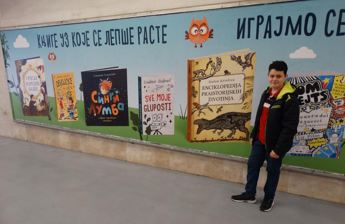  Dušan Krtolica stands before a wall ad featuring his encyclopedia of prehistoric animals. (Courtesy of <a href="https://www.facebook.com/Du%C5%A1an-Krtolica-DinoBoy-1385486281748877">Dušan Krtolica</a>)