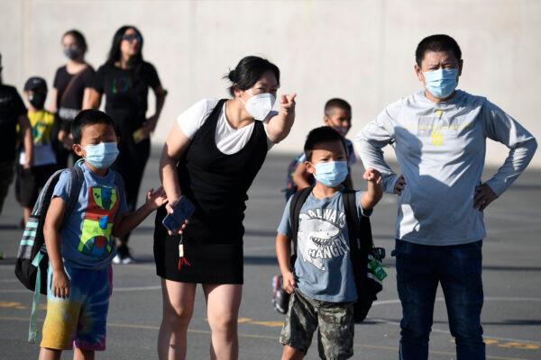 Masked parents direct their children on the first day of school at Enrique S. Camarena Elementary School in Chula Vista, Calif. on July 21, 2021. (Denis Poroy/AP Photo)