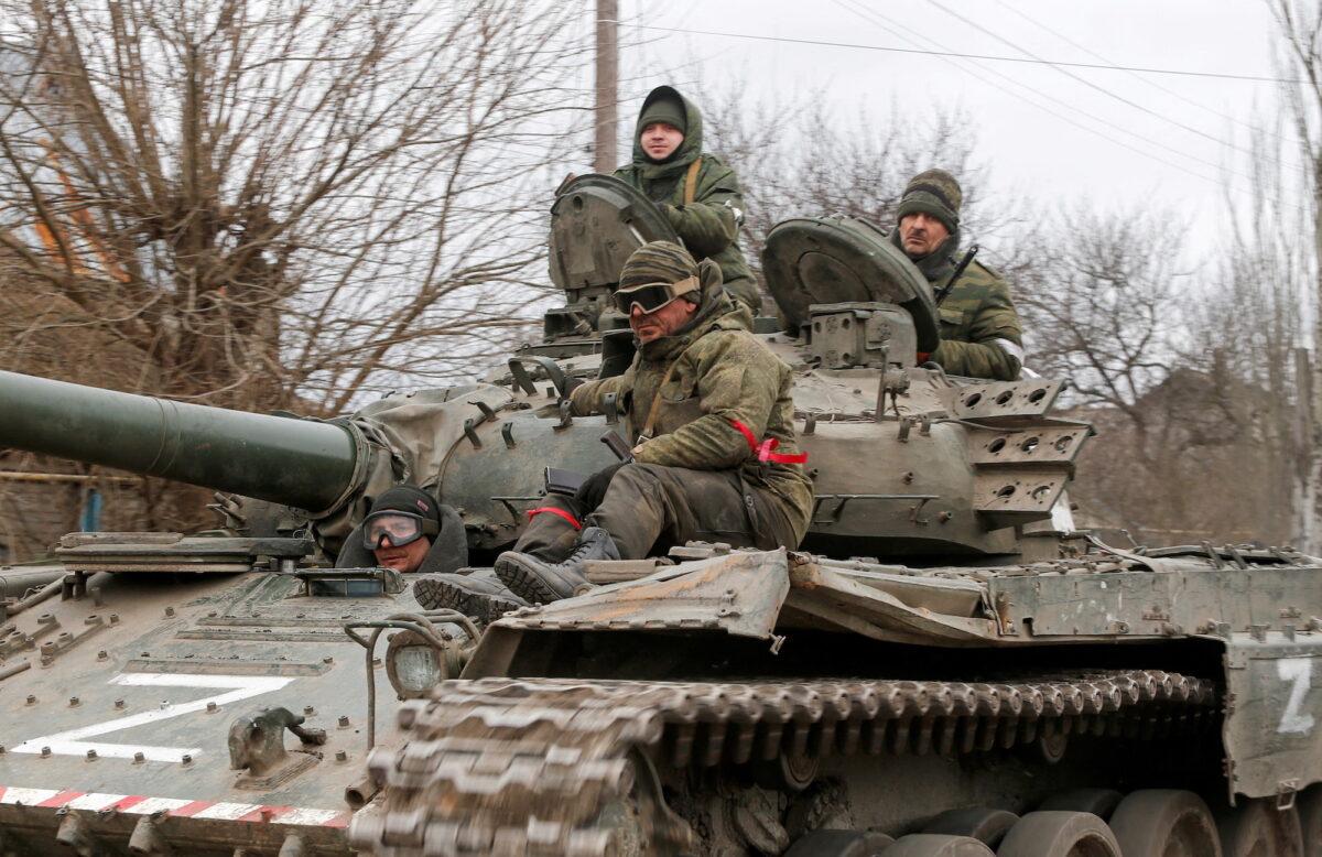 Service members of pro-Russian troops in uniforms without insignia are seen atop of a tank with the letter "Z" painted on its sides in the separatist-controlled settlement of Buhas, in the Donetsk region, Ukraine, on March 1, 2022. (Alexander Ermochenko/Reuters)